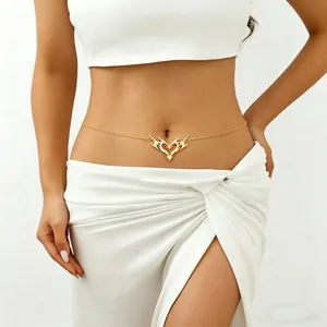 Detail view of a stylish gold thorny heart waist chain jewelry on female model's belly