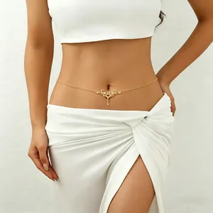 Close-up of vintage gold engraved heart body chain worn on waist with white outfit.