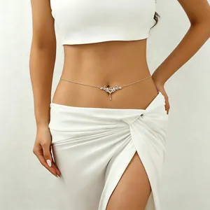 Close-up shot of a silver vintage carved thorn heart belly chain jewelry on a model.