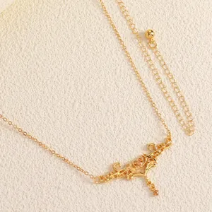 Close-up of vintage gold body chain featuring an ornate thorn heart carved pendant with beads