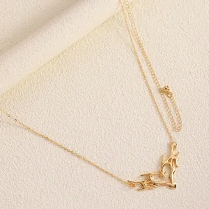 Close-up of vintage carved thorn heart pendant on a gold-tone delicate body chain