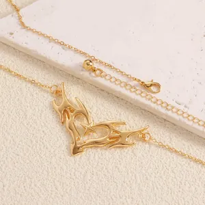 Detail of gold thorny heart body chain with star accent and lobster clasp closure