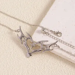 Close-up detail of silver thorn heart body chain with star pendant in punk style