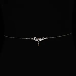 Close-up of vintage silver body chain with thorny heart and amber droplet detail