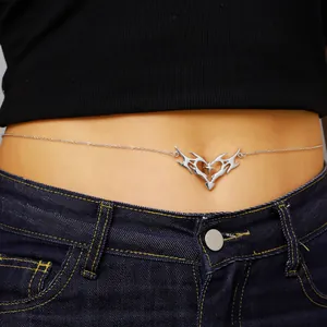 Close-up detail of a vintage thorny heart body chain worn with denim jeans for women.