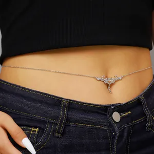 Detail view of vintage silver thorny heart belly chain on model's waist in beach style