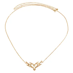 Detailed view of the gold thorn heart pendant on a delicate adjustable body chain
