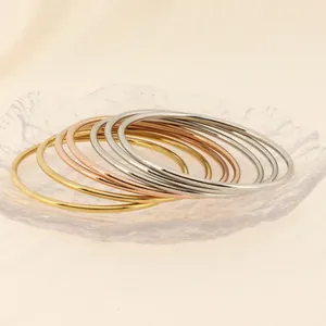 Vista detallada de pulseras apilables de acero inoxidable de 3 mm en oro, rosa y plata