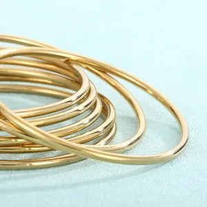 Macro view of high-quality gold-plated stainless steel stackable bangles with smooth finish