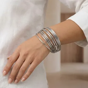 Detailed close-up of stacked 3mm silver stainless steel bangles on model's wrist