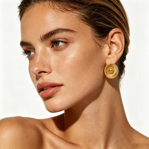 Elegant gold titanium sunburst stud earrings with central bead on a female model