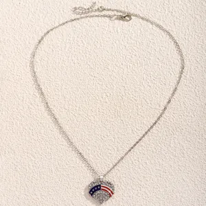 Close-up of heart pendant with USA flag design and crystals on silver chain necklace