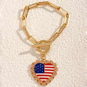 Detail of gold chain bracelet with US flag heart pendant and decorative toggle clasp