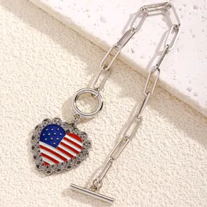Detail of silver heart flag pendant with toggle clasp on textured stone surface
