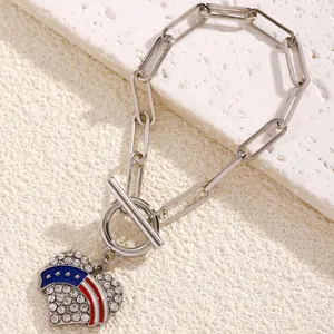 Macro shot of silver heart pendant with US flag enamel and rhinestones on stone background