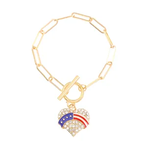 Detailed view of golden paperclip bracelet with heart US flag pendant and OT clasp closure