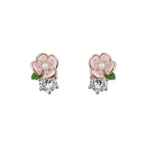 Élégantes boucles d'oreilles fleur en émail rose avec perle et accents de zircon brillant.