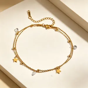 Macro detail of an elegant double-layered gold anklet featuring star charms and clear crystals