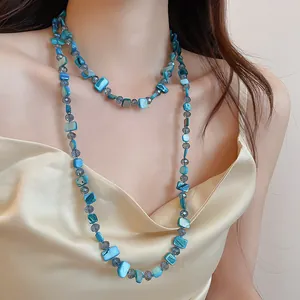 Vue détaillée d'un collier multicouche en coquillages turquoise et perles de cristal