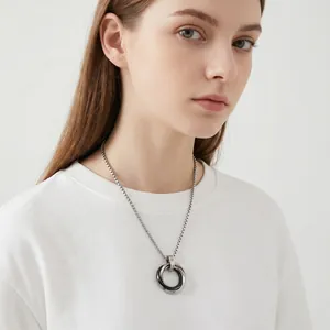 Detailed macro view of minimalist stainless steel double ring necklace worn by a female model
