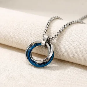 Close-up of interlocking silver and blue stainless steel ring pendant on box chain.