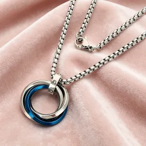 Close-up of stainless steel interlocking silver and blue rings on pink velvet fabric