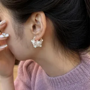 Detail view of elegant silver-toned floral hoop earrings with delicate pearl accents