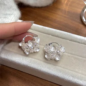 Close-up detail of elegant flower basket earrings with pearls and diamonds on display tray.