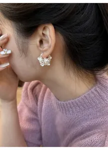 Elegant silver blossom flower basket hoop earrings shown in detailed close-up on model ear