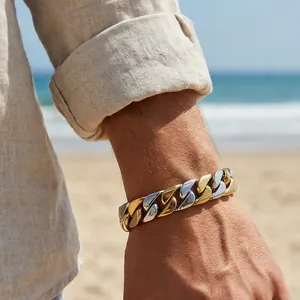Zweifarbiges massives Panzerarmband für Herren in Gold und Silber am Strand