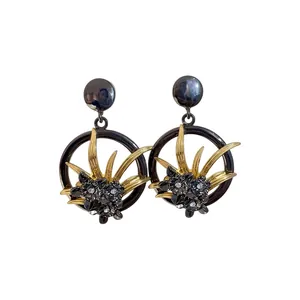 Orecchini vintage a fiori traforati con foglie dorate e strass neri per donna.