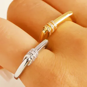 Close-up of gold and silver rectangular open rings with micro-pave cubic zirconia on finger