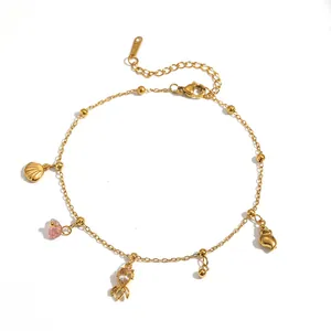 Close-up detail of a gold-plated stainless steel anklet with shell and lobster charms