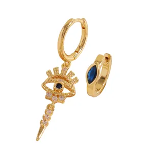 Macro detail of gold evil eye earring with blue stones and sparkling cubic zirconia