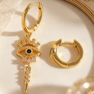 Macro shot of gold evil eye earring with blue stone and sparkling diamonds inlay