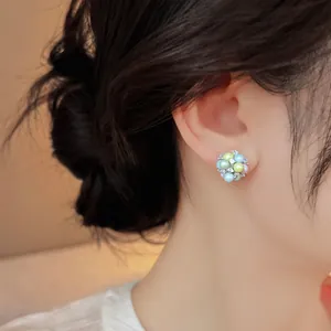 Close-up of a colorful dopamine acrylic rhinestone stud earring on an ear