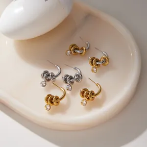 Détail de créoles plaquées or 18 carats avec zircon et anneaux mobiles sur marbre