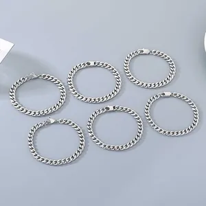 Six bracelets gourmette en acier inoxydable avec fermoirs mousqueton sur fond gris