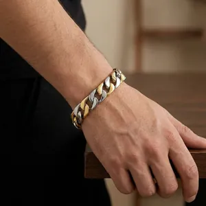 Macro detail of men's two-tone Cuban link bracelet showing gold and silver polished links
