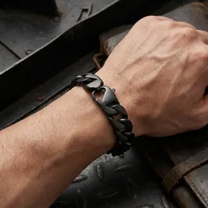 Close-up of men's matte black Cuban chain bracelet on vintage leather background