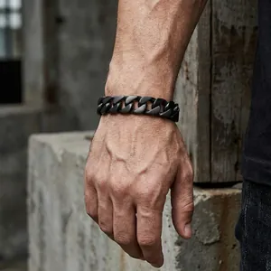 Detail of matte black cuban link chain bracelet on male wrist in industrial setting