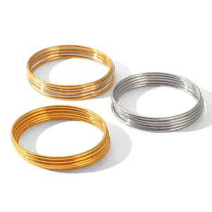 Detailed shot of five-piece stackable stainless steel bangles in gold and silver finish