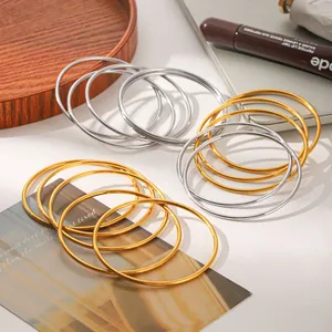 Detail view of minimalist stainless steel bangle set in gold and silver finish