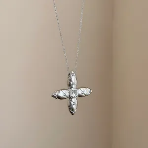 Close-up detail showing quilted texture on silver cross star pendant necklace with crystal