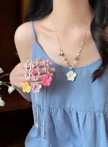 Handgefertigte bunte Blumenperlenkette für Damen an einem eleganten weiblichen Model
