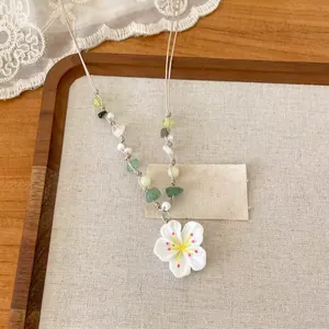 Vue détaillée rapprochée d'un collier de perles avec pendentif fleur de cerisier