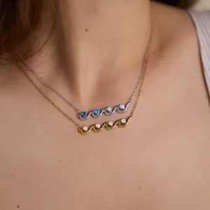 Close-up detail of stylish gold and silver wave-shaped necklaces with sparkling zircon accents