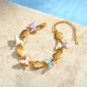 Detailed view of colorful enamel butterfly charms on gold stainless steel bracelet.