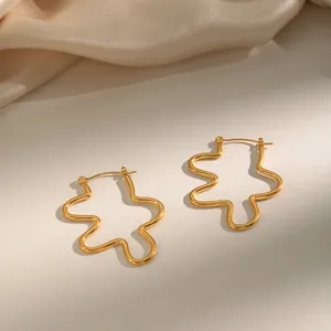 Detailed macro view of stylish 18K gold-plated stainless steel wavy line hoop earrings