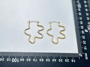 Detailed view of 18K gold plated wavy hoop earrings with measurement scale markers